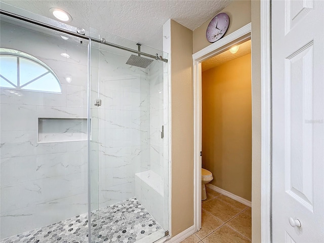 bathroom featuring toilet, a textured ceiling, tile patterned flooring, and an enclosed shower