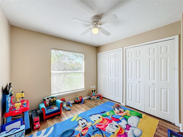 game room with ceiling fan, a textured ceiling, and hardwood / wood-style floors