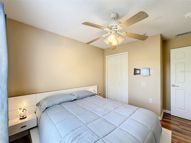 bedroom featuring a closet, ceiling fan, hardwood / wood-style flooring, and a textured ceiling