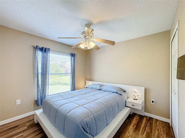 bedroom with a textured ceiling, dark hardwood / wood-style floors, and ceiling fan