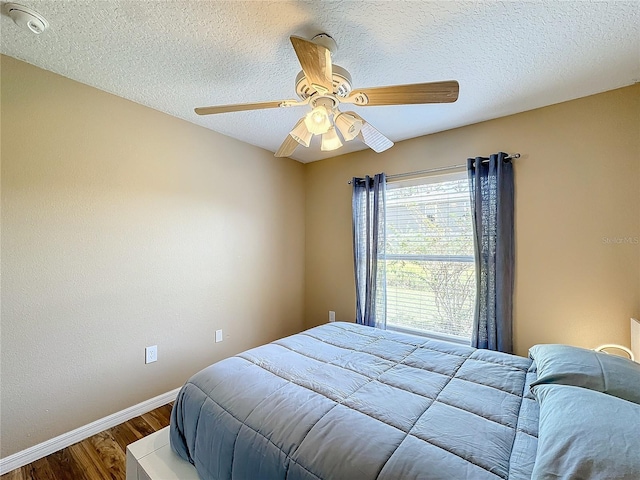 bedroom featuring a textured ceiling, wood-type flooring, and ceiling fan