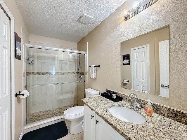 bathroom featuring toilet, a shower with shower door, a textured ceiling, and vanity