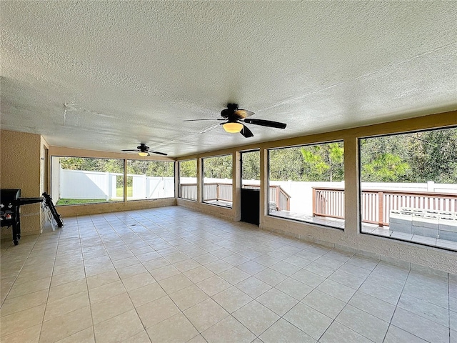 unfurnished sunroom featuring ceiling fan