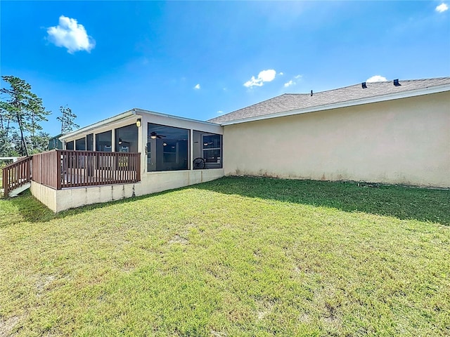 view of yard featuring a wooden deck and a sunroom