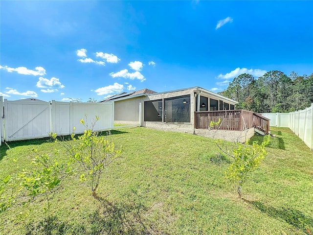 rear view of property with a wooden deck and a lawn