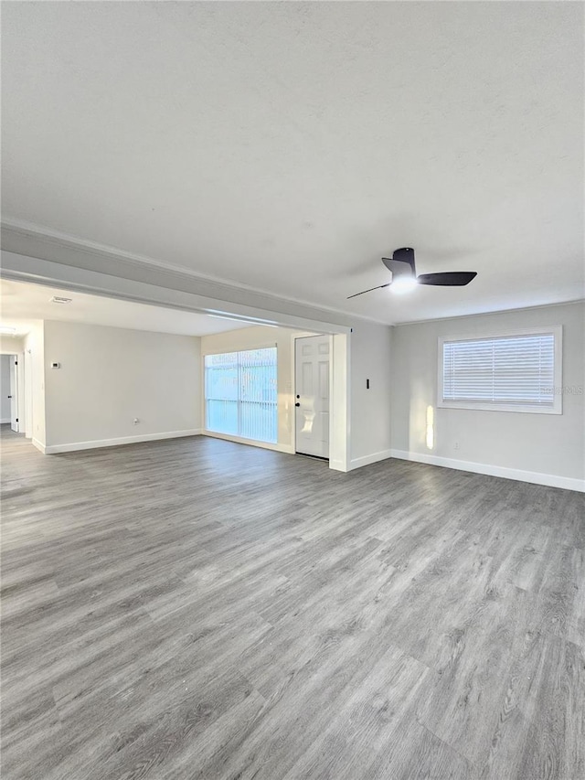 unfurnished living room featuring ceiling fan and hardwood / wood-style flooring