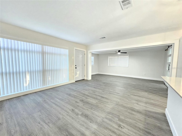 unfurnished living room with ceiling fan and wood-type flooring