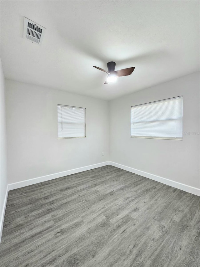 empty room with ceiling fan and dark hardwood / wood-style floors