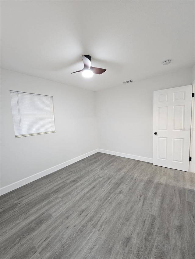 unfurnished room with dark hardwood / wood-style floors and ceiling fan