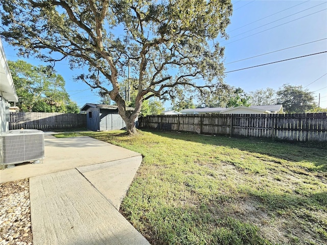 view of yard featuring central AC, a patio, and a shed