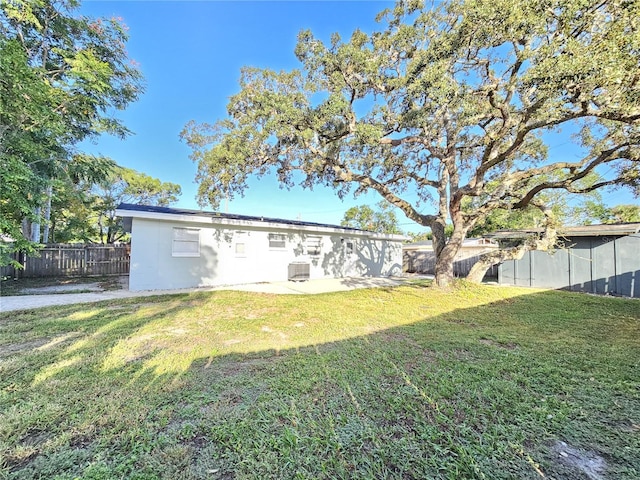 back of house with central air condition unit, a patio area, and a lawn