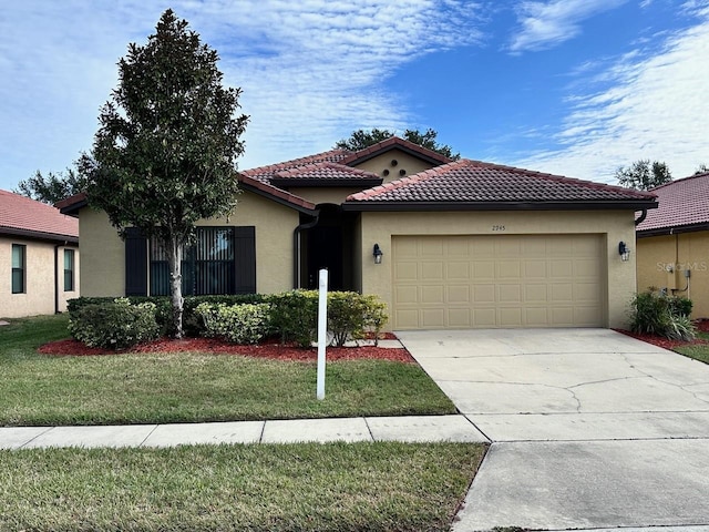 mediterranean / spanish house featuring a garage and a front lawn