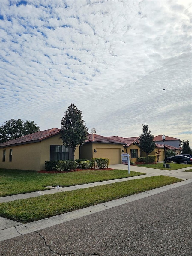 single story home with a garage and a front lawn