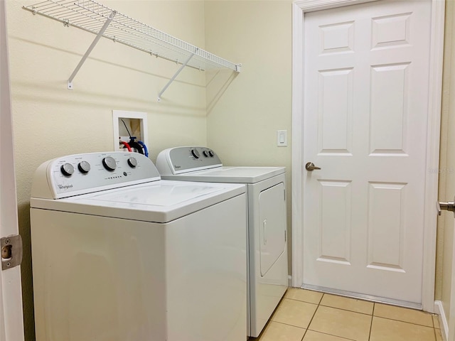 washroom with washer and clothes dryer and light tile patterned flooring