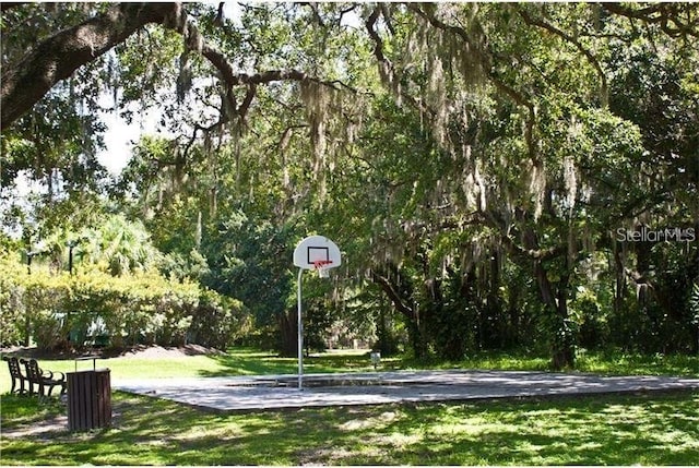 view of basketball court with a yard