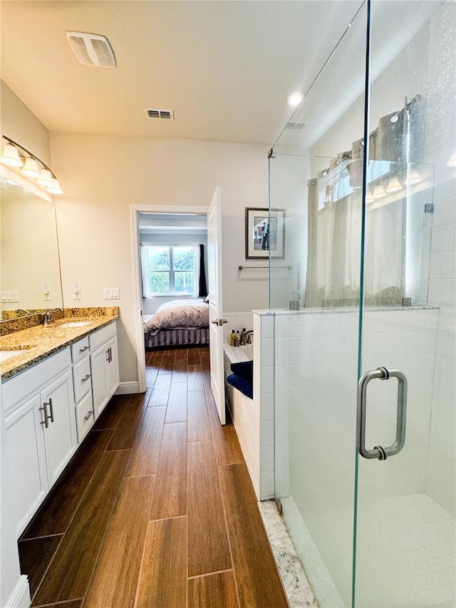 bathroom featuring vanity, hardwood / wood-style floors, and a shower with shower door