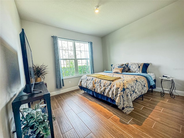 bedroom featuring wood-type flooring and a textured ceiling