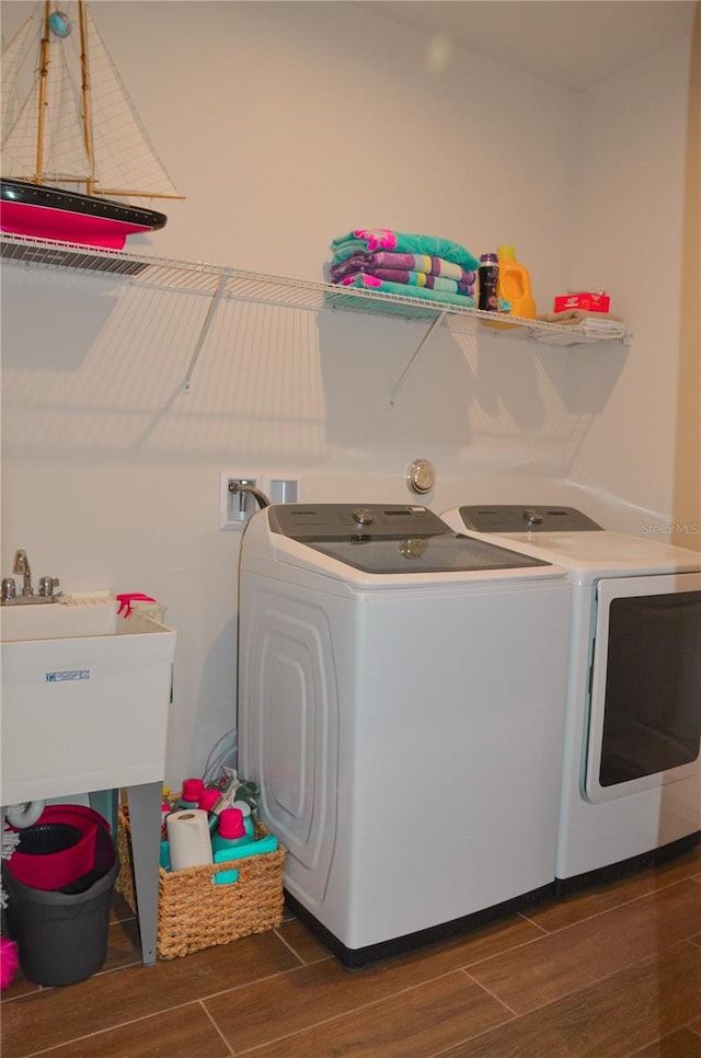 laundry area featuring sink, separate washer and dryer, and dark hardwood / wood-style flooring