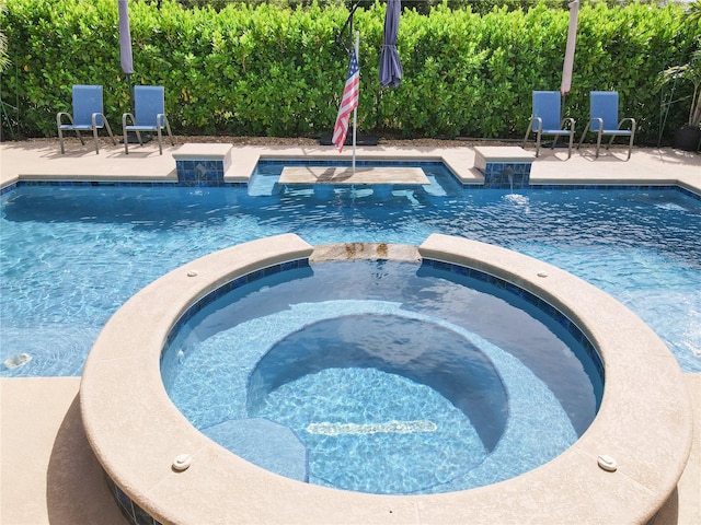 view of swimming pool with an in ground hot tub and a patio