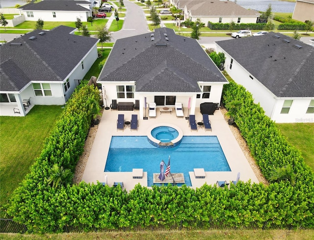 view of pool with a patio, an in ground hot tub, and a lawn