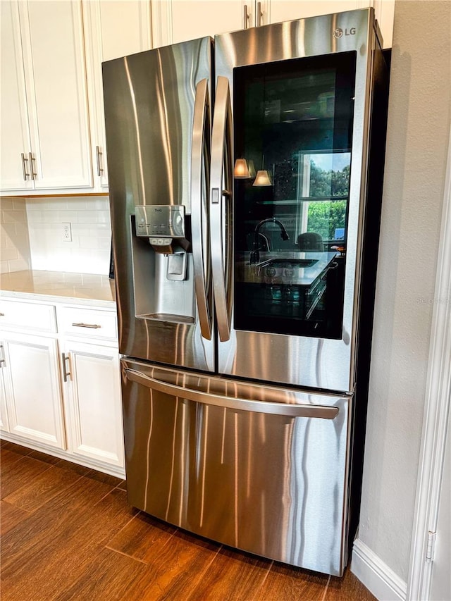 kitchen featuring white cabinetry, stainless steel fridge, backsplash, and dark hardwood / wood-style flooring