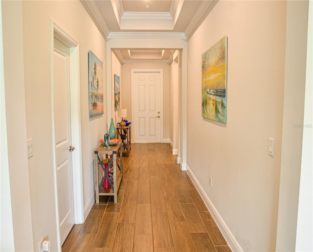 hallway featuring ornamental molding, dark wood-type flooring, and a raised ceiling