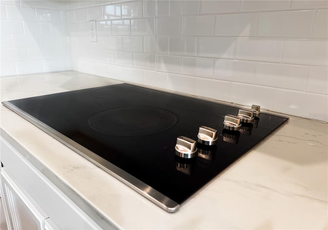 details featuring black electric stovetop and decorative backsplash