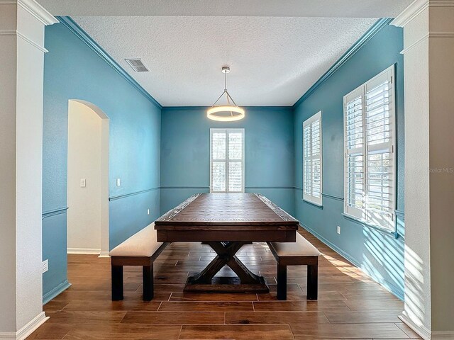 dining area with crown molding, dark hardwood / wood-style floors, and a wealth of natural light