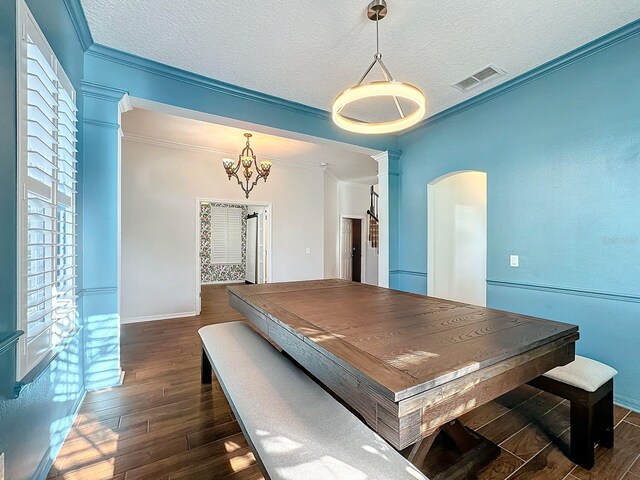 dining area featuring crown molding, a textured ceiling, and dark hardwood / wood-style flooring