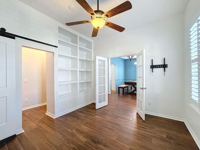 unfurnished bedroom featuring french doors, multiple windows, and dark hardwood / wood-style floors