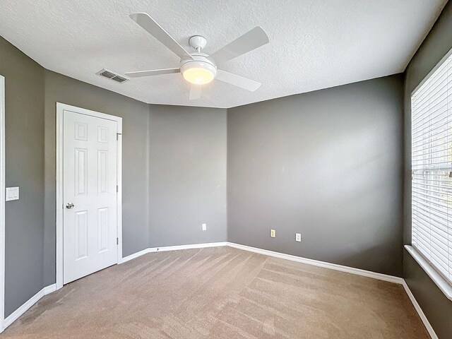 spare room with ceiling fan, a textured ceiling, and carpet floors