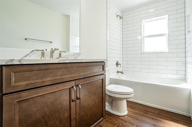 full bathroom featuring toilet, tiled shower / bath, hardwood / wood-style floors, and vanity