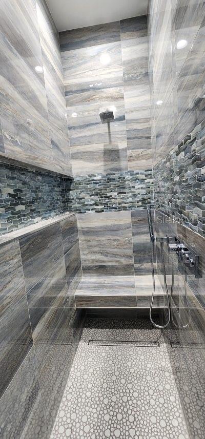 bathroom featuring tile walls and a shower