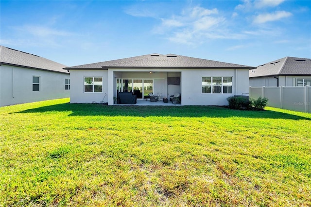 rear view of property featuring a yard and a patio area