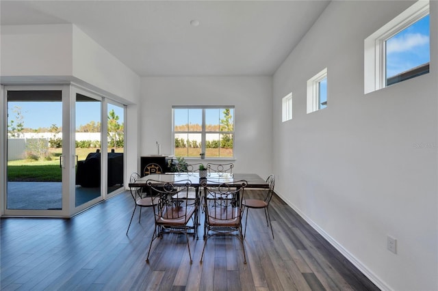 dining area with baseboards and dark wood-style flooring