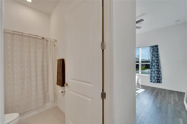 bathroom featuring toilet, ceiling fan, wood-type flooring, and walk in shower