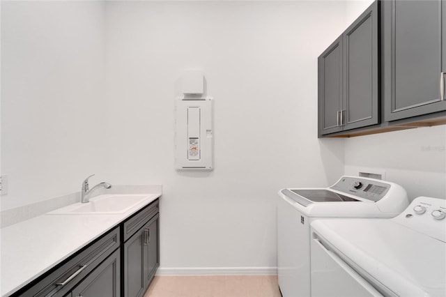 washroom with cabinets, light tile patterned flooring, washer and clothes dryer, and sink