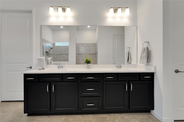 bathroom with a walk in shower, double vanity, and a sink