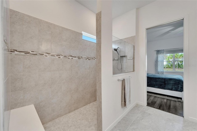 ensuite bathroom with a walk in shower, connected bathroom, and baseboards