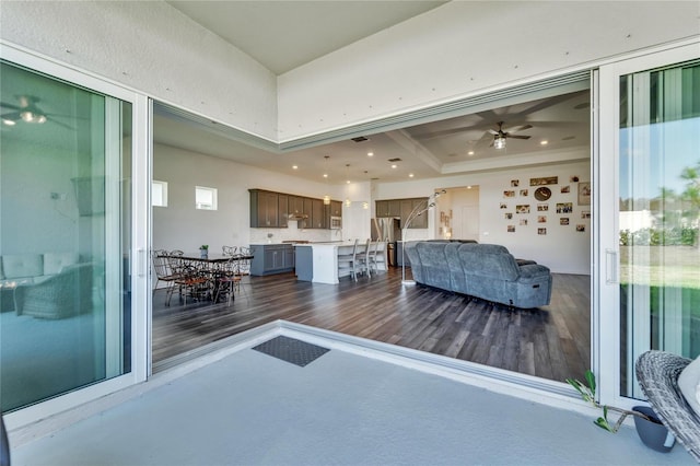 living room featuring a tray ceiling, ceiling fan, and dark hardwood / wood-style floors