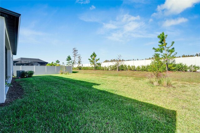 view of yard with a fenced backyard and central AC unit