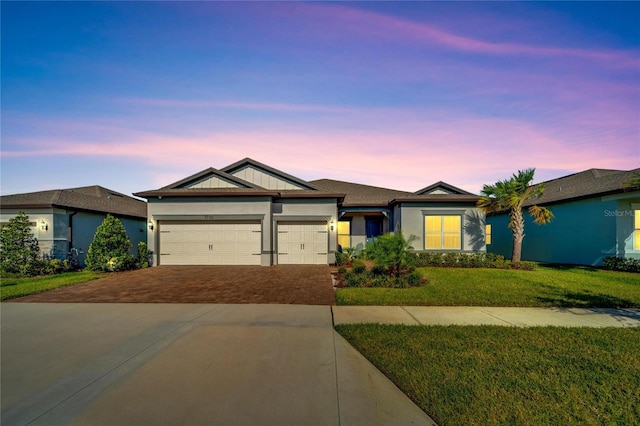 view of front facade with a yard and a garage