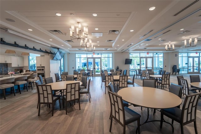 dining area with a tray ceiling, a wealth of natural light, and hardwood / wood-style flooring