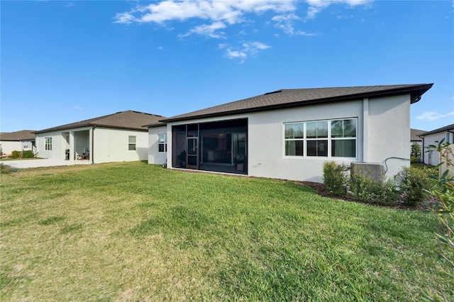 rear view of property with a sunroom, a lawn, and stucco siding