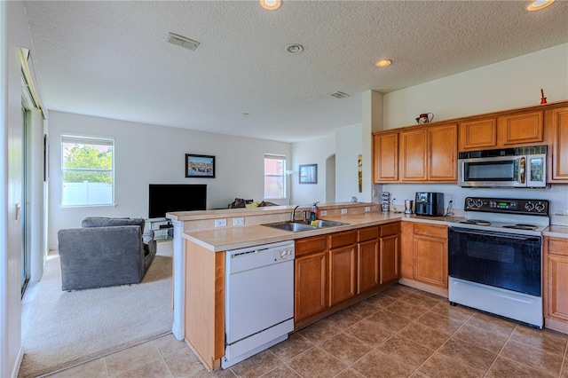 kitchen with dishwasher, range with electric cooktop, kitchen peninsula, sink, and carpet floors