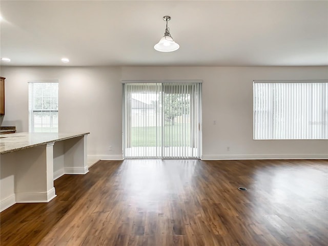 unfurnished dining area featuring dark hardwood / wood-style flooring