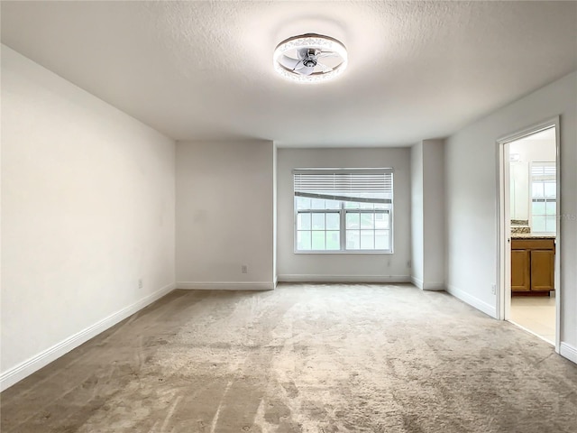 carpeted empty room with a textured ceiling