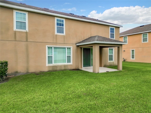 back of property featuring a patio area and a lawn