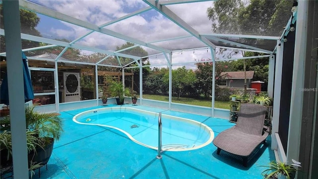 view of swimming pool featuring glass enclosure