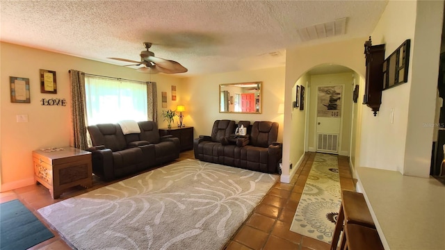 tiled living room with a textured ceiling and ceiling fan